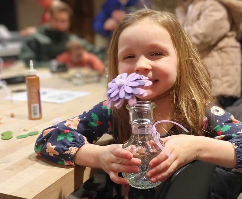 a child holds a bouquet of crafted felt flowers background image